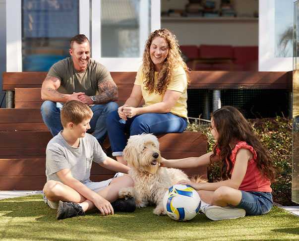 Family sitting together with their dog in the backyard
