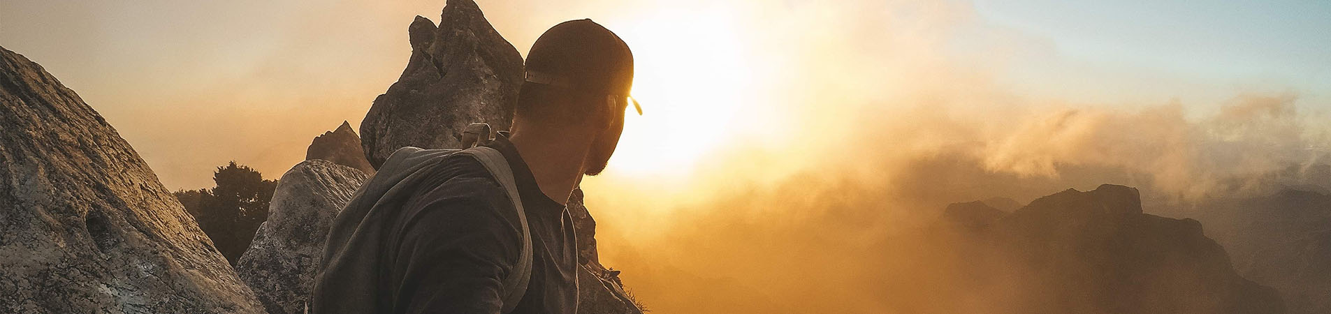 Sunset abseiling veteran on top of mountain looking at sunset