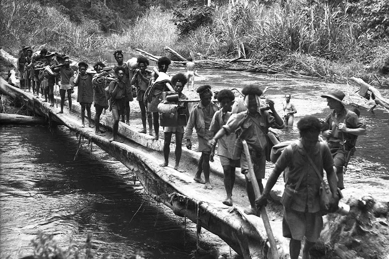 Papuan carriers and Australian troops crossing the Brown River on the Kokoda 	Trail, 1942. Photo credit: Australian War Memorial 027050