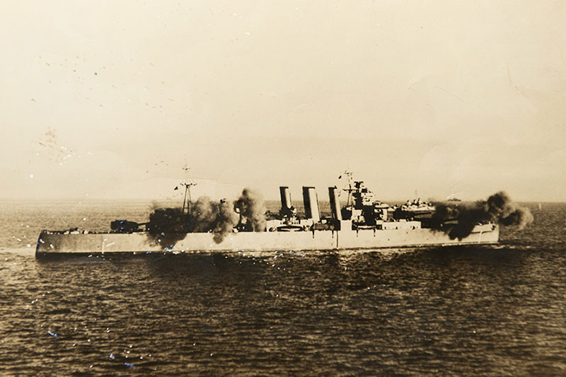 HMAS Shropshire carrying out a shore bombardment, circa 1944