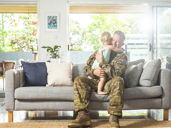Soldier on couch hugging child