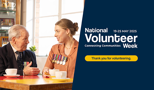 Veterans sitting together at a table talking. National Volunteer Week text overlay