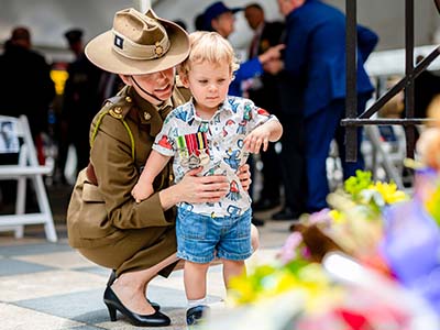 Defence Staff with Child lays wreath Remembrance Day 2021