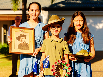 3 Kids commemorating with items on ANZAC Day