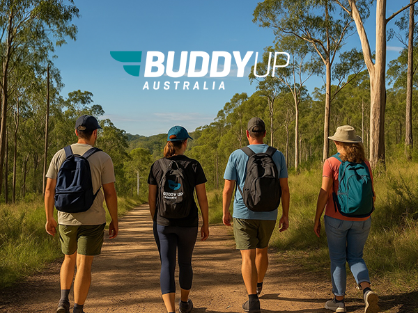 Four people walking along a dirt track