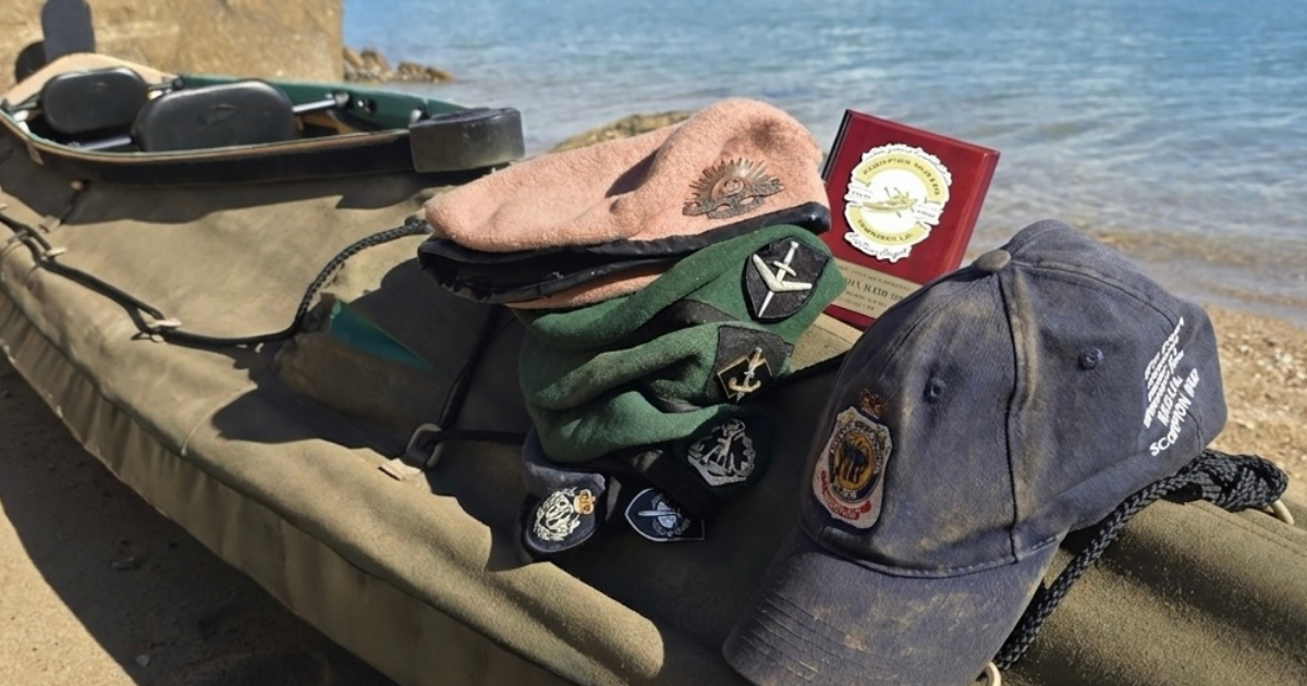 Canoe on the beach with berets and an RSL QLD hat