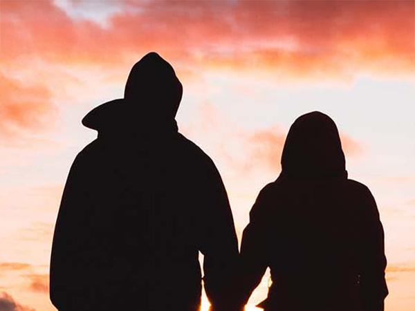 ADF couple holding hands watching the sunset
