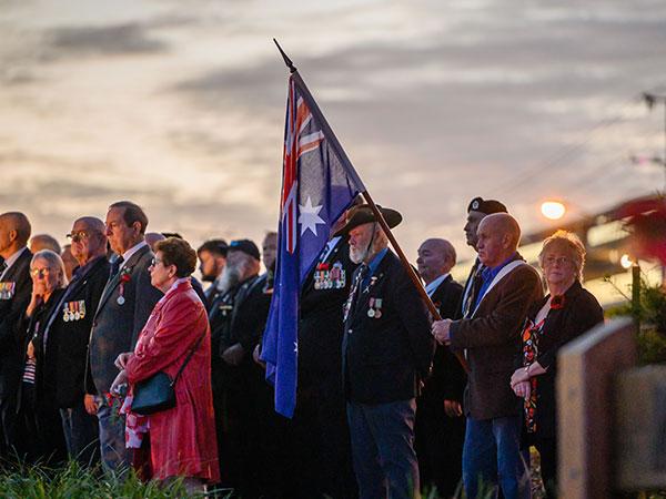 Current serving, veterans and partners standing together at an ANZAC Day Dawn Service
