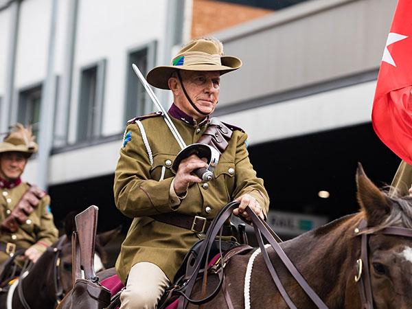 Army personnel on horse back riding in an ANZAC Day March